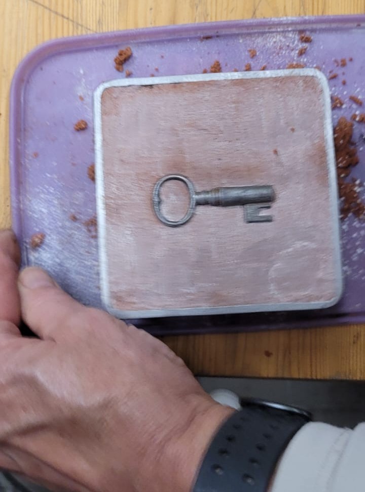 Avain asetettu hiekan päälle muottiin